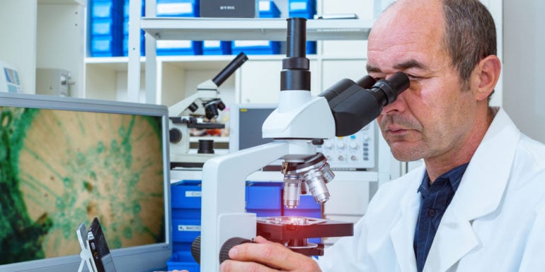 Scientist looking into a microscope